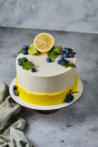 Gâteau au citron garni de citron, de lime et de baies fraîches. Dessert personnalisé pour votre anniversaire.