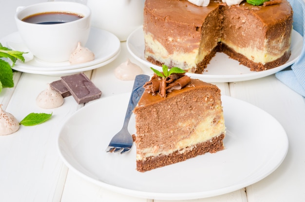 Gâteau au fromage au chocolat et au café avec de la meringue, de la guimauve et du chocolat sur le dessus