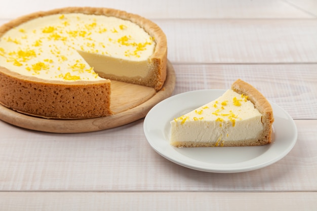 Gâteau au fromage au citron fait maison et morceau de tarte près de l'assiette