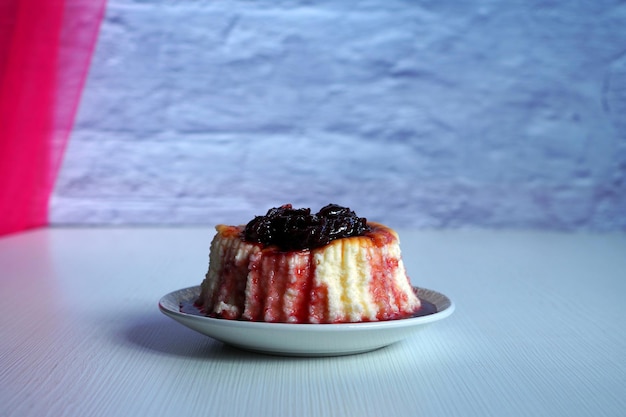 Gâteau au fromage au sirop de cerise sur une plaque blanche