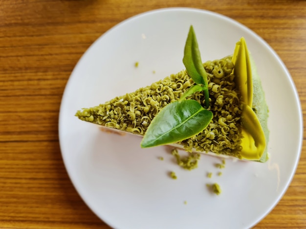 Gâteau au fromage au thé vert sur une plaque blanche sur une table en bois