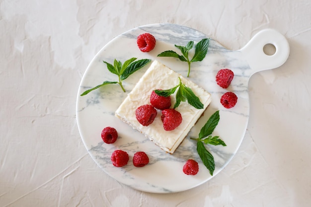 Gâteau au fromage aux framboises garni de feuilles de menthe Sur fond clair Le concept de la fête israélienne Chavouot