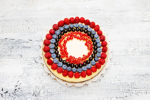 Gâteau au fromage aux framboises et myrtilles sur table en bois