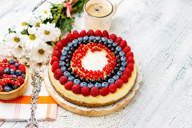 Gâteau au fromage aux framboises et myrtilles sur table en bois