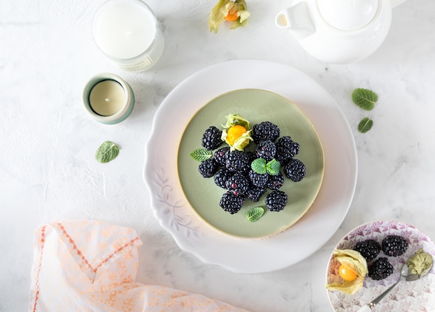 Gâteau au fromage aux mûres fait maison et thé matcha sur la table de fête Dessert à la crème de gélatine aux baies Vue de dessus