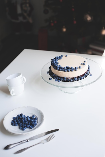 Gâteau au fromage aux myrtilles sur support en verre avec tasse et couverts