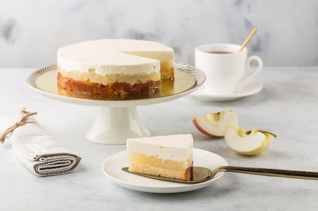 Gâteau au fromage aux pommes sur cake stand et tasse de thé fond blanc