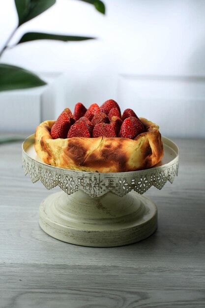 Gâteau au fromage brûlé basque sur fond noir, gâteau au fromage viral avec fraise sur le dessus. Copier l'espace pour le texte