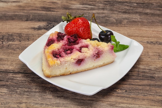 Un gâteau au fromage avec des cerises et des fraises.