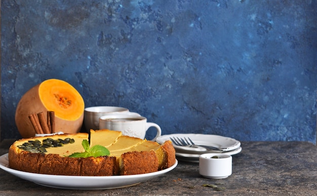 Gâteau au fromage à la citrouille classique fait maison sur un fond de béton bleu. Mise au point horizontale.