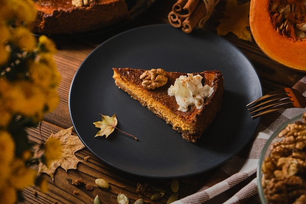 Gâteau au fromage à la citrouille fait maison décoré de crème fouettée.