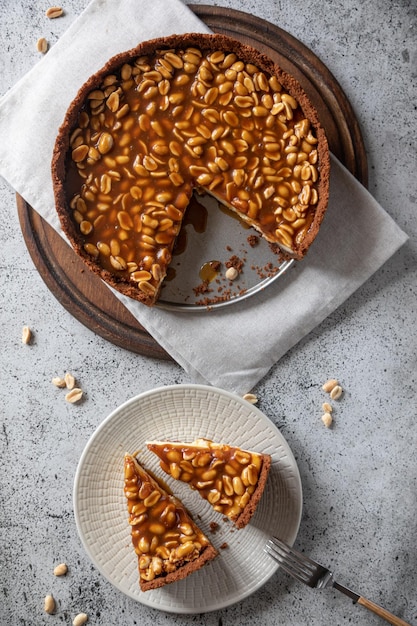 Gâteau au fromage fait maison au caramel et aux arachides sur fond clair Matin délicieux gâteau de boulangerie