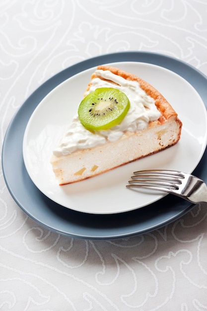 Gâteau au fromage fait maison avec des kiwis et de la crème