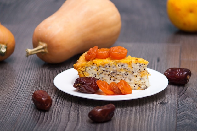 Gâteau au fromage ou gâteau fait maison à la citrouille avec abricots secs, pavot, orange, fruit de la datte.