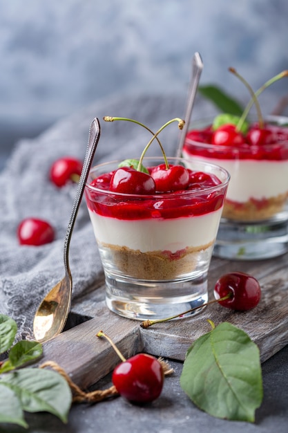 Gâteau au fromage léger avec de la gelée de cerise dans un verre.