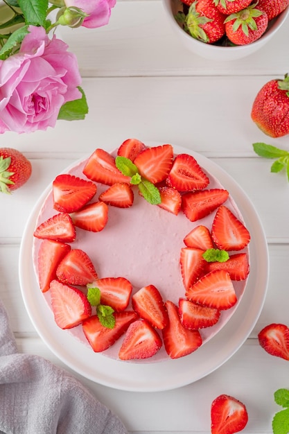 Gâteau au fromage sans cuisson avec des fraises fraîches sur un fond en bois blanc Dessert d'été