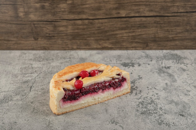 Gâteau au fromage sucré en tranches avec sirop de baies sur table en pierre.