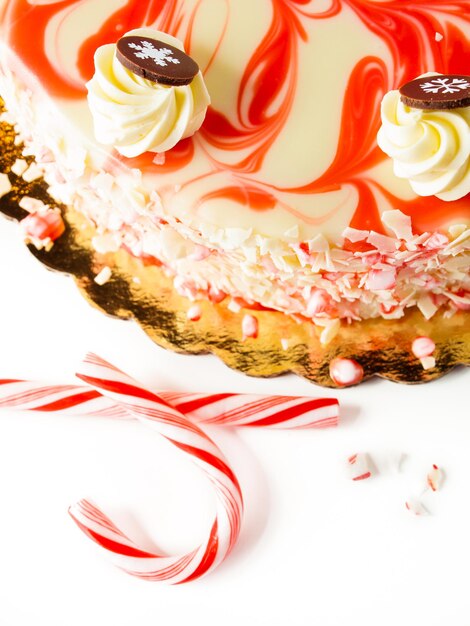 Gâteau au fromage traditionnel de Noël au chocolat blanc et menthe poivrée sur fond blanc.