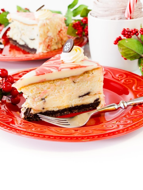 Gâteau au fromage traditionnel de Noël au chocolat blanc et menthe poivrée sur fond blanc.