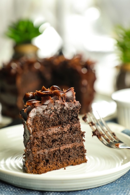 Gâteau au fudge au chocolat avec fourchette et couteau servi dans une assiette sur la table des aliments, vue de dessus, café, dessert