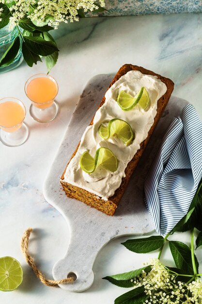 Gâteau au pain sucré d'été sur une table avec des fleurs et un verre dans des verres.