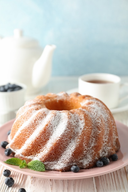 Gâteau au sucre en poudre et aux bleuets sur fond de bois