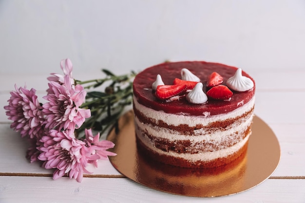 Gâteau au yaourt au chocolat et aux fraises décoré de fruits frais sur une table en bois Gâteau aux fraises rose délicieux et sucré pour la Saint-Valentin ou une fête d'anniversaire Concept de boulangerie maison