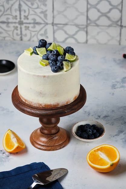 Gâteau aux agrumes sur un support en bois, sur la table de la cuisine.