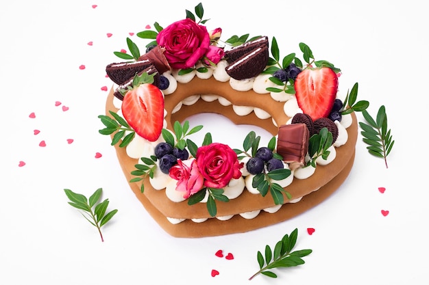 Gâteau aux biscuits - un gâteau en forme de cœur avec de la crème et des fruits. Dessert le jour de la Saint-Valentin.