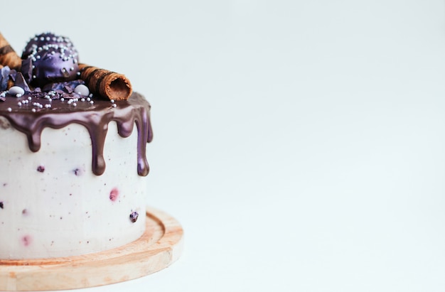 Gâteau aux bleuets paillettes violettes avec glaçage au chocolat sur fond blanc