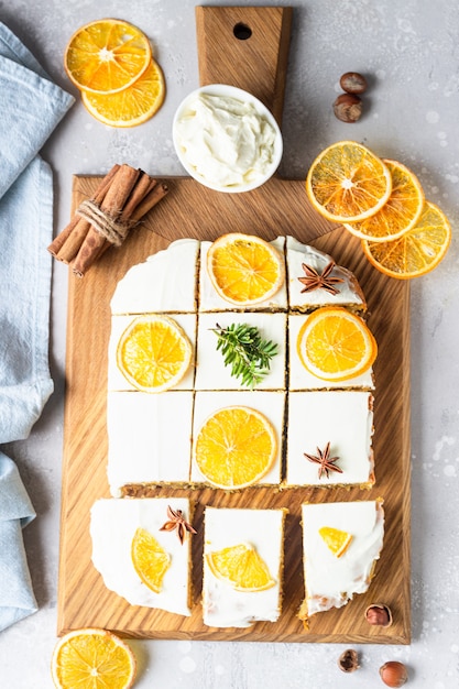 Gâteau aux carottes crues avec glaçage au fromage à la crème, tranches d'orange séchée et épices (cannelle et anis).