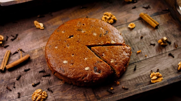 Gâteau aux carottes décoré de bâtons de cannelle et de noix