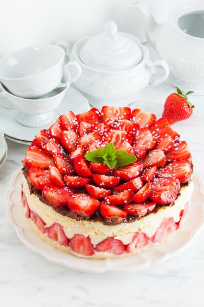 Gâteau aux fraises Fraisier sur la plaque blanche et tasses pour le thé