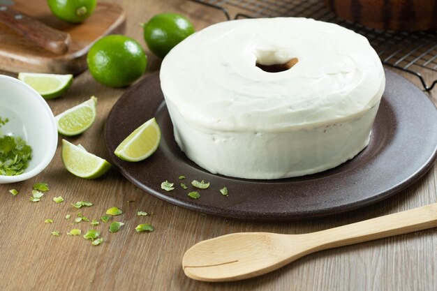 Gâteau aux fruits au citron moelleux sur une assiette avec des tranches de citron sur une table en bois Délicieux petit-déjeuner l'heure du thé traditionnel recette de gâteau au citron