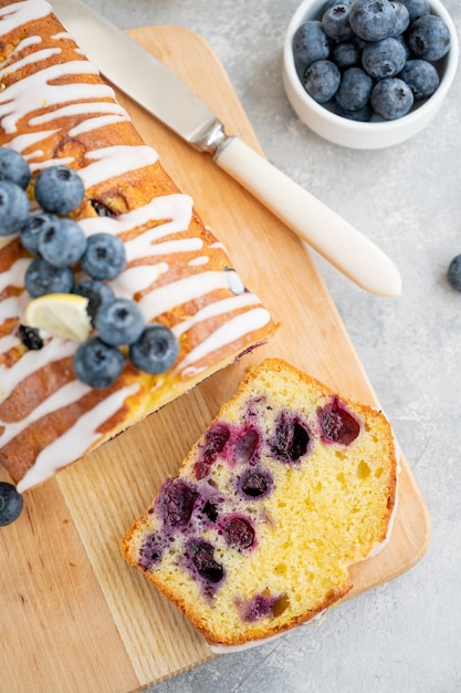 Gâteau aux myrtilles au citron avec glaçage au citron et baies fraîches sur le dessus du plateau