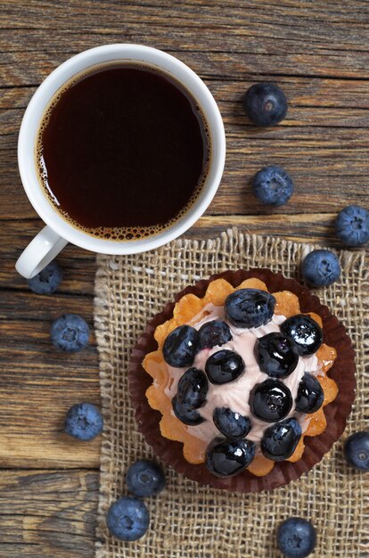 Gâteau aux myrtilles et café sur table en bois