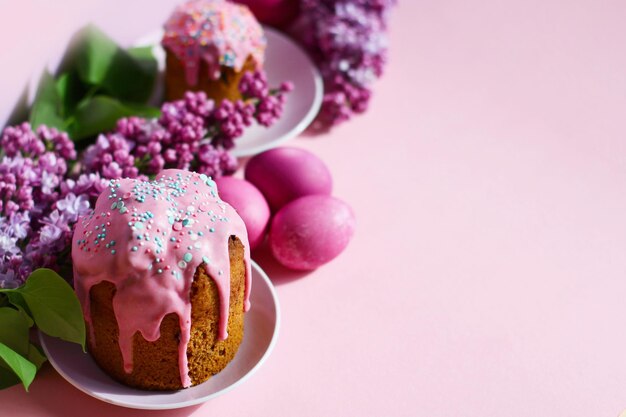 Gâteau aux oeufs de pâques violet vif et fleurs lilas sur fond violet décor de Pâques