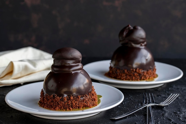 Photo gâteau aux profiteroles sur un fond sombre gâteau au chocolat liquide et aux profiteroles en gros plan vue horizontale