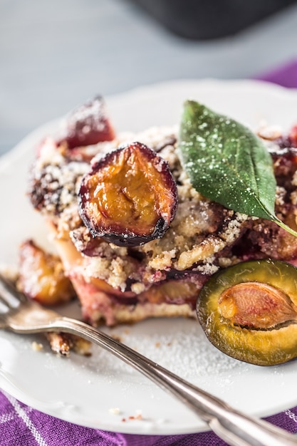 Photo le gâteau aux prunes sucré traditionnel sur plaque blanche.