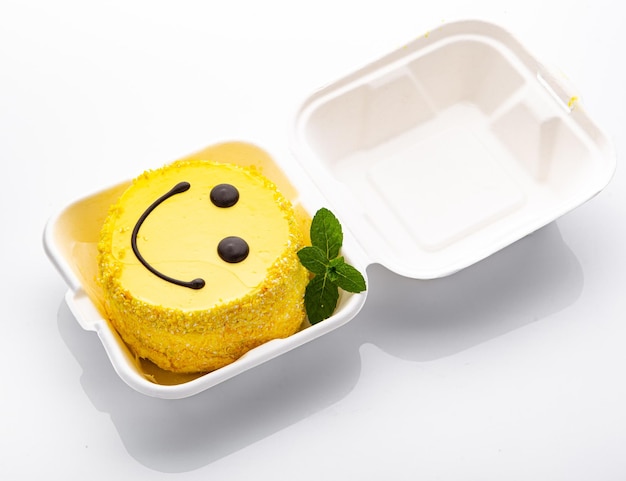 Gâteau bento avec motif smiley et coeurs dans un emballage en plastique