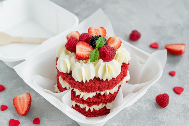 Gâteau bento en velours rouge Petit gâteau dans une boîte à lunch sur fond de béton gris Gâteau de Saint Valentin