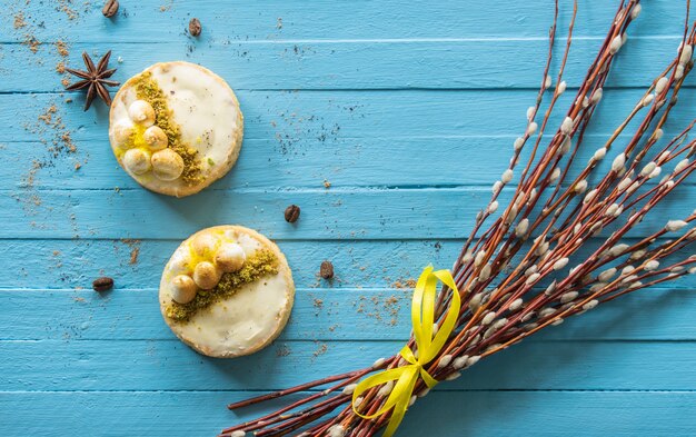 Gâteau blanc sur un fond en bois branches de saule et vue de dessus de bonbons