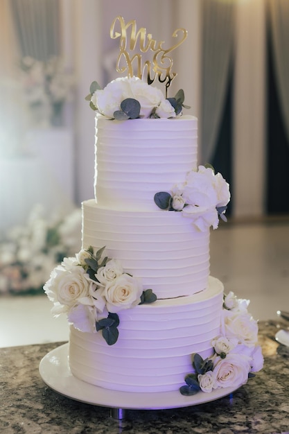 Photo un gâteau blanc à trois niveaux avec des fleurs blanches