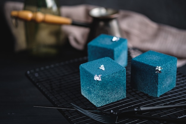 Gâteau bleu en forme de cube. Style rustique.