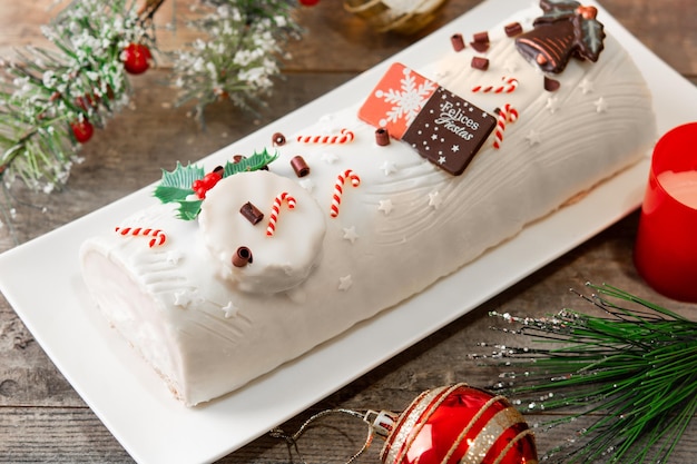 Gâteau de bûche au chocolat blanc avec ornement de Noël isolé sur fond blanc