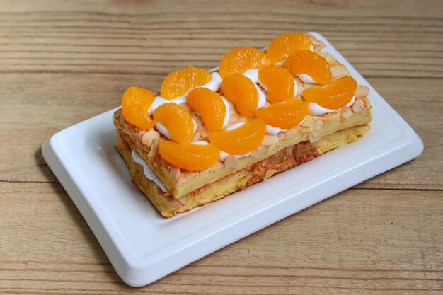 Gâteau de Budapest à la crème et recouvert de fruits frais à la mandarine