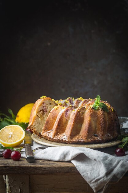 Gâteau Bundt au citron fait maison avec du sucre glace sur fond noir