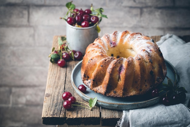 Gâteau bundt frais fait maison avec cerise sur table en bois