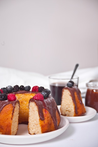 Gâteau bunt vanille aux baies et verre de café sur le fond.