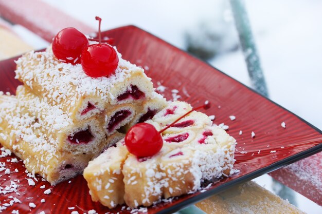 Photo gâteau cabane monastique avec une cerise sur la neige